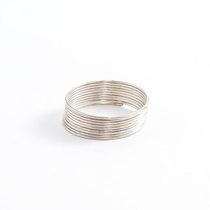 May include: A silver ring made of multiple thin bands stacked on top of each other.