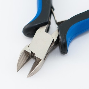 May include: Close-up of a pair of blue and black wire cutters with a silver cutting blade.