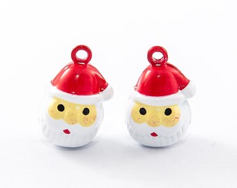 Könnte beinhalten: Zwei Santa Claus-förmige Ornamente. Jedes Ornament hat einen roten Hut, einen weißen Bart und ein gelbes Gesicht mit schwarzen Augen. Sie haben eine kleine Schlaufe oben zum Aufhängen.