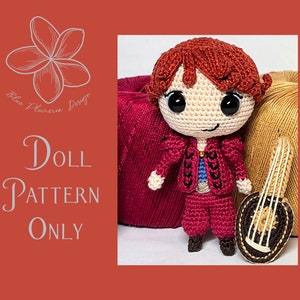 May include: Crochet doll pattern for a red-haired doll with a red and blue outfit holding a small lute. The doll is sitting on a red and gold fabric background. The text "Doll Pattern Only" is visible in the image.