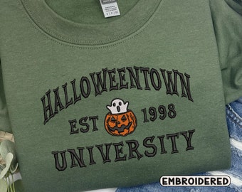 May include: Green sweatshirt with embroidered text that reads "Halloweentown Est 1998 University" with a ghost and pumpkin graphic. The text is in a black font and the graphic is in orange and white.