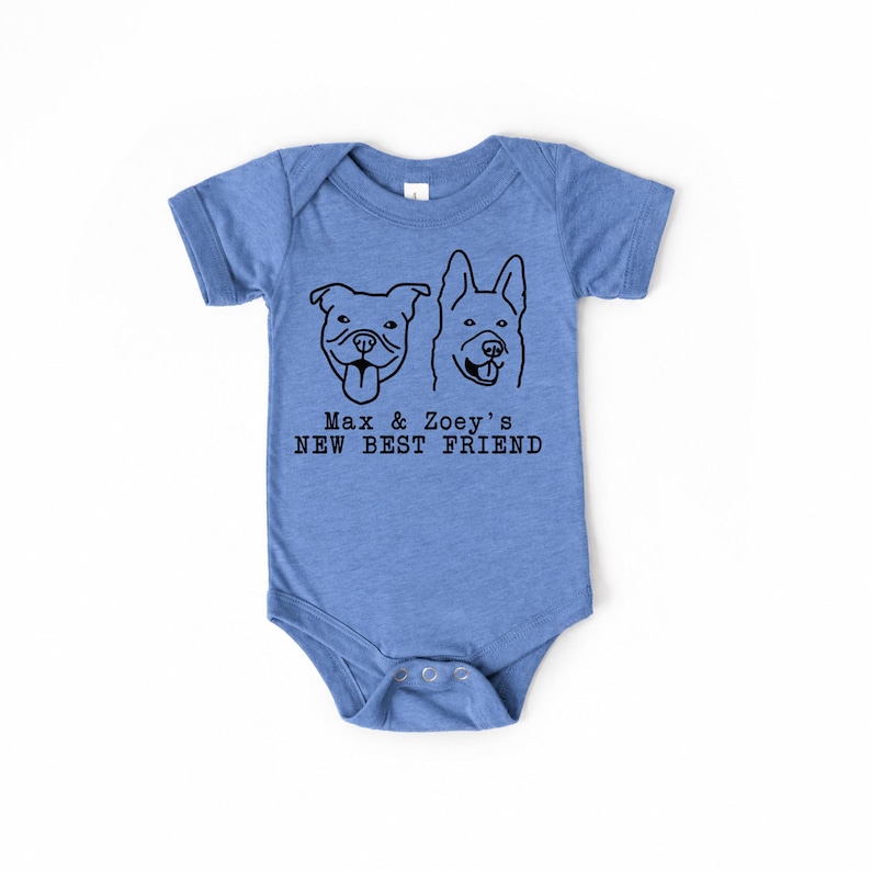 May include: A heather blue short-sleeve baby bodysuit featuring a black line art graphic of two dog faces. Below the dogs, the text reads: Max & Zoey's NEW BEST FRIEND. The garment has a crew neckline and a snap closure at the bottom crotch area.