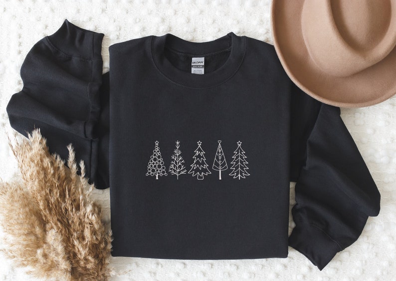 May include: Black sweatshirt featuring a white outline of five Christmas trees. The trees are decorated with baubles and stars.