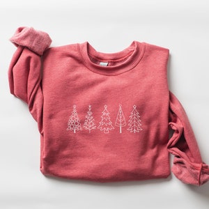 May include: A red sweatshirt with a white outline of five Christmas trees on the front.