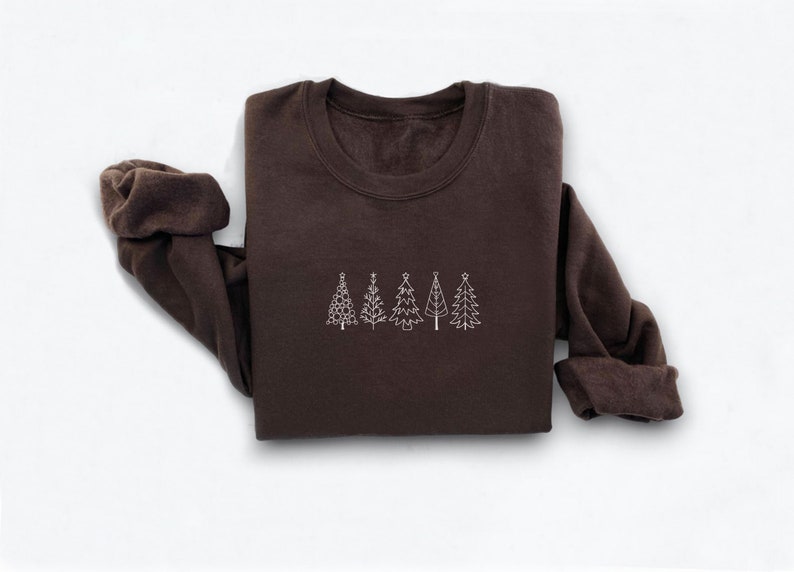 May include: A brown sweatshirt with a white outline of five Christmas trees on the front.