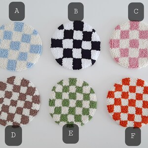 May include: Six round, crocheted checkerboard coasters in various colors, including blue, black, pink, brown, green, and orange. The coasters are labeled A through F.