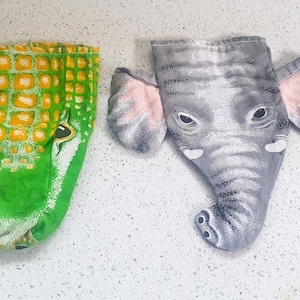 May include: Two fabric hand puppets, one green with a crocodile face and the other gray with an elephant face.