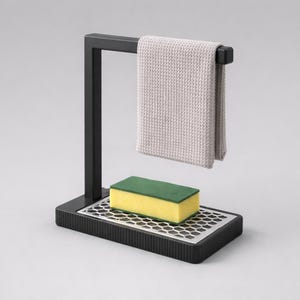 May include: A black metal kitchen sink tidy with a light grey towel hanging from the top. A yellow and green sponge sits on a silver grate above a black base. The design is modern and minimalist.