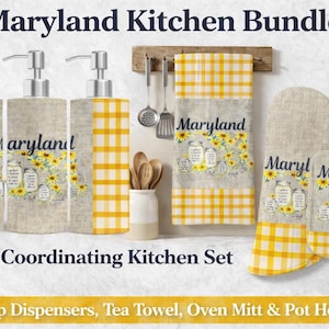 Può includere: Un set da cucina coordinato con dispenser di sapone, un canovaccio, un guanto da forno e un sottopentola. Il set presenta un motivo a quadri gialli e bianchi, con la scritta "Maryland" e illustrazioni di girasoli.
