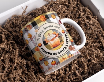 Könnte beinhalten: Eine weiße Keramiktasse mit einem schwarz-weißen Karomuster und Herbstmotiven. Die Tasse trägt den Text "Falling leaves and pumpkin spice lattes".