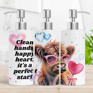 May include: Three white ceramic soap dispensers with a silver pump top. The dispensers feature a Highland cow with pink sunglasses and a pink lollipop. The dispenser on the left has the text "Clean hands happy heart, it's a perfect start".