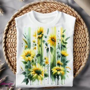 May include: White t-shirt with a watercolor design of sunflowers and greenery. The sunflowers are yellow with brown centers and the greenery is green and white.