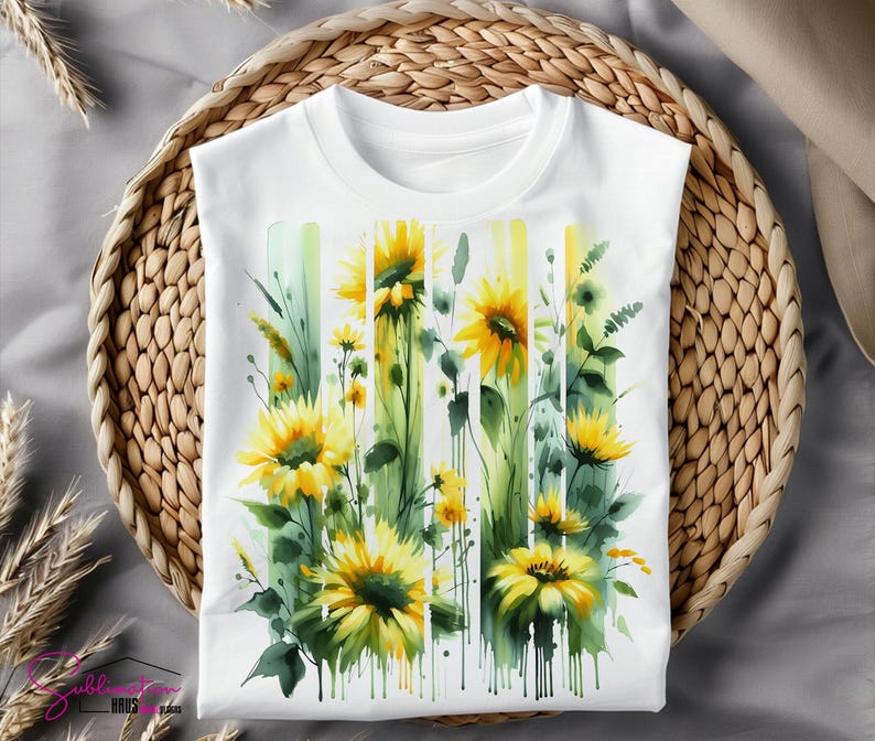 May include: White t-shirt with a watercolor design of sunflowers and greenery. The sunflowers are yellow with brown centers and the greenery is green and white.