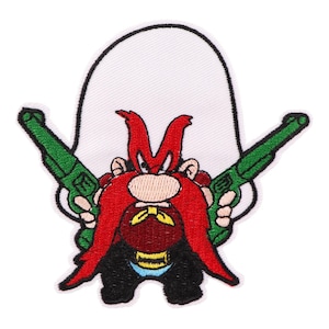 Puede incluir: Un parche bordado para planchar con un personaje de dibujos animados con barba y bigote rojos y sombrero, sosteniendo dos pistolas verdes. El personaje lleva un traje negro y un cinturón amarillo.