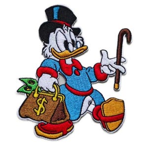 May include: Embroidered patch featuring Scrooge McDuck, a cartoon duck in a blue suit, black top hat, and red bow tie. He carries a money bag with a dollar sign and a cane. The patch has yellow, red, blue, black, and white colors.