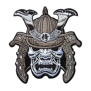 Puede incluir: Parche bordado con un casco de samurái con una cara de demonio feroz, blanca y negra. El casco es marrón y tiene un carácter kanji blanco en la parte delantera.