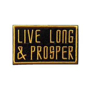 Op de afbeelding: Zwarte geborduurde patch met een gouden rand. De patch zegt "Live Long & Prosper".