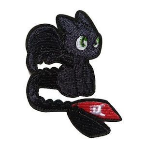 Op de afbeelding: Geborduurde patch met een zwarte draak met groene ogen en een rood-zwarte staart. De draak heeft een schattig, cartoonachtig ontwerp, ideaal voor het versieren van kleding of accessoires.