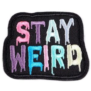 Könnte beinhalten: Ein schwarzer Bügeleisen-Aufnäher mit den Worten "Stay Weird" in tropfenden Regenbogenfarben.
