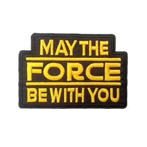 May include: Black embroidered patch with yellow text that reads "May the Force Be With You".