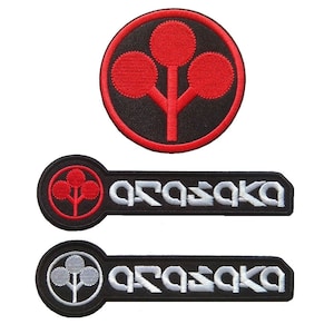 May include: Three embroidered patches. The top patch is circular with a red tree design on a black background, surrounded by a red border. The other two patches are rectangular with the word "ARASAKA" in white and a tree design.
