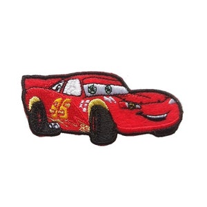 Könnte beinhalten: Rotes Cartoon-Rennwagen mit schwarzen Reifen und einer weißen Nummer 95 an der Seite. Das Auto hat ein lächelndes Gesicht mit grünen Augen und einen gelben Streifen auf der Motorhaube.