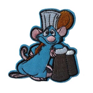 Könnte beinhalten: Ein gestickter Bügelaufkleber mit einer blauen Comic-Maus, die einen Kochhut trägt und eine braune Tasse hält. Die Maus hat rosa Ohren und eine rosa Nase.