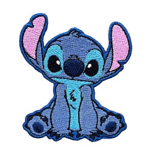 Puede incluir: Un parche bordado con Stitch, un personaje de la película de Disney Lilo & Stitch. Stitch está sentado con los brazos cruzados y tiene una gran sonrisa en la cara. El parche es azul y rosa.