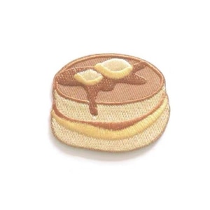 Puede incluir: Un parche bordado de planchar de un panqueque con jarabe y mantequilla, en marrón y amarillo.