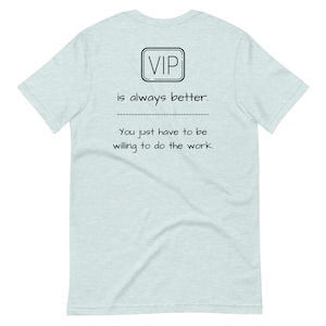 May include: Light blue t-shirt with a black square that says "VIP" and the text "is always better. You just have to be willing to do the work."