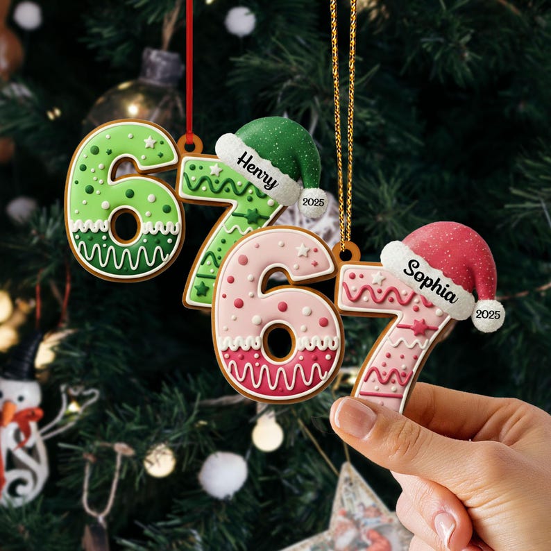 May include: Gingerbread-style Christmas ornaments shaped like the numbers 6 and 7, decorated with icing and festive details. Each ornament has a Santa hat with a name and the year 2025. One is held by a hand.
