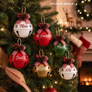 May include: Six round metal jingle bell ornaments in white, red, green, and gold. Each bell features a red and white checkered bow, pinecones, and red berries on top. The names Mom, Emma, Max, Dad, Taylor, and Lily are printed on the bells.