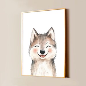 Op de afbeelding: Een ingelijste kunstdruk met een aquarelillustratie van een lachende husky-pup. De pup heeft een grijs-witte vacht, roze wangen en een zwarte neus, afgebeeld tegen een effen witte achtergrond in een dunne, goudkleurige metalen lijst.