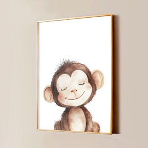 Op de afbeelding: Een ingelijste kunstdruk met een aquarelillustratie van een bruine aap met gesloten ogen en een zachte glimlach. De aap heeft een lichtbruin gezicht en borst met donkerder bruine vacht op het hoofd en lichaam, tegen een witte achtergrond.