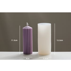May include: Two candle molds, one is a purple pillar candle mold measuring 4 inches in diameter and 11.5 inches tall, the other is a white cylindrical mold measuring 5.5 cm in diameter and 12.3 cm tall.