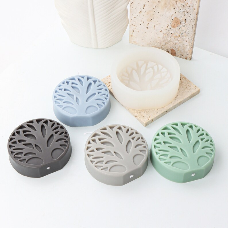 May include: Five silicone molds for making candles or soap. The molds are round and feature a tree design. The molds are in various colors, including gray, green, blue, and white.