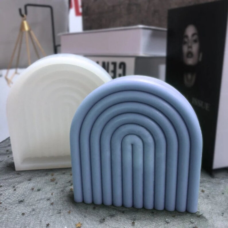 May include: Two arch-shaped silicone molds for crafting. One mold is white and the other is light blue with a multi-layered design.