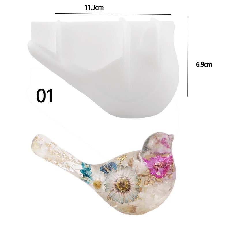 May include: A white silicone mold shaped like a bird, measuring 11.3 cm wide and 6.9 cm tall. The mold is designed to create resin crafts. The number "01" is printed on the mold. A finished resin bird with dried flowers is shown below the mold.