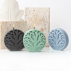 May include: Three round candles with a tree design. The candles are in black, green, and blue.