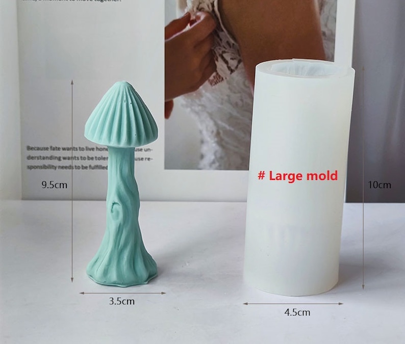 K&ouml;nnte beinhalten: Eine hellblaue Silikonform in Form eines Pilzes mit einem strukturierten Stiel. Die Form ist 9,5 cm hoch, 3,5 cm breit und 4,5 cm im Durchmesser. Die Form ist mit "# Gro&szlig;e Form" gekennzeichnet.