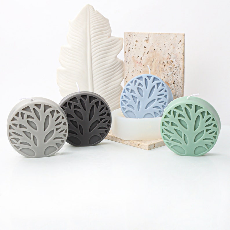 May include: Four round candles with a tree design. The candles are in gray, black, blue, and green.