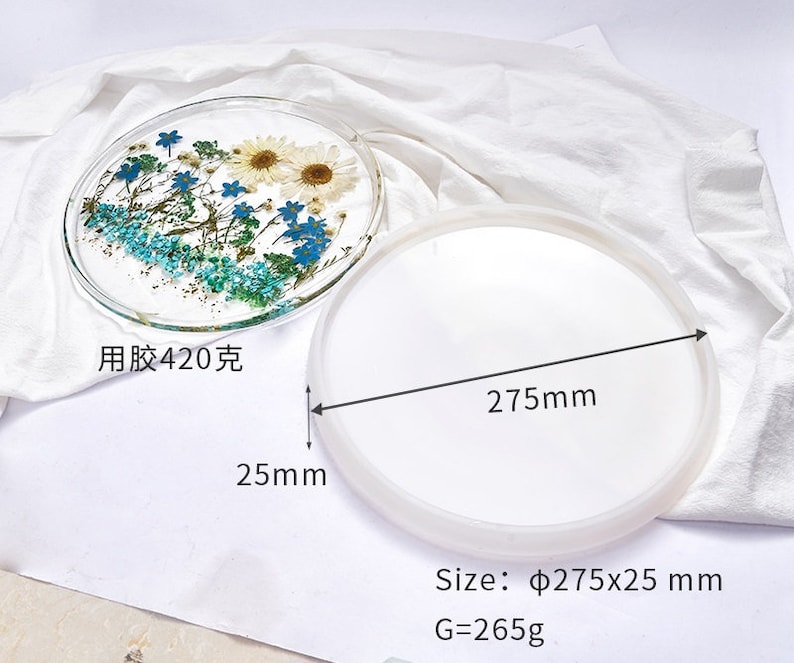 May include: A white silicone mold for resin casting, measuring 275 mm in diameter and 25 mm in height. The mold is shown next to a finished resin tray with pressed flowers, measuring 420 grams. The finished tray is clear with blue and white flowers.