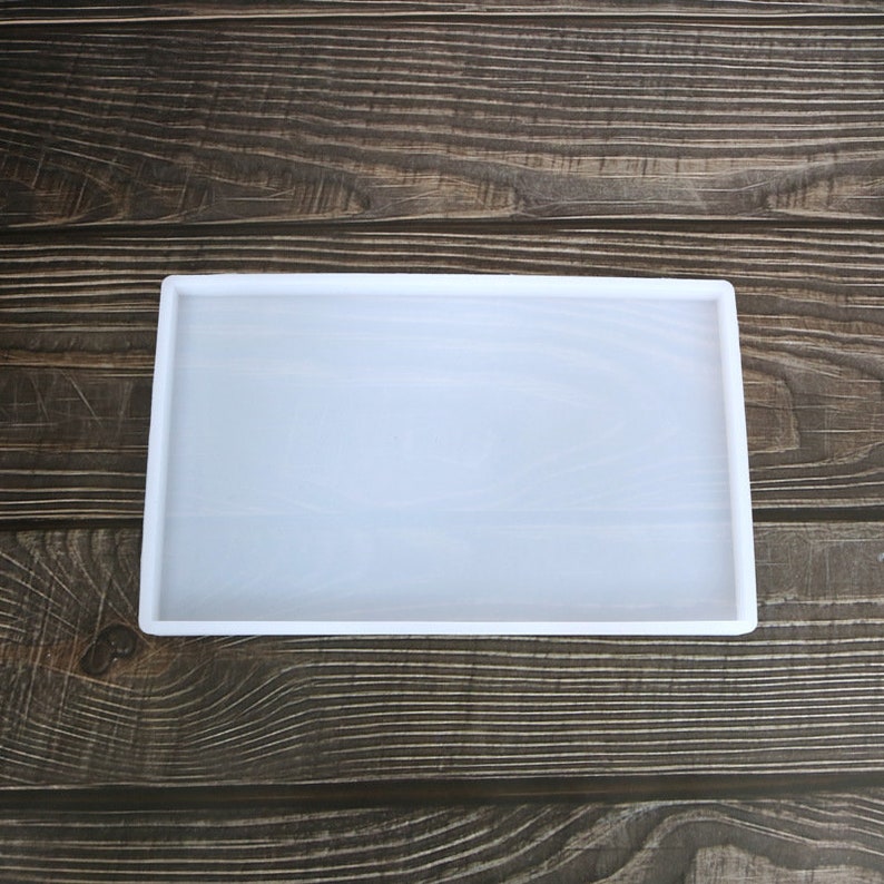 May include: A white silicone mould for resin casting. The mould is rectangular and has a smooth surface.