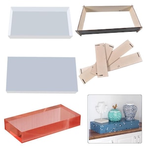 May include: A set of three clear acrylic display trays, two rectangular and one long rectangular, with a wooden frame and dividers. The trays are perfect for displaying small items, such as jewelry, candles, or other decorative objects.