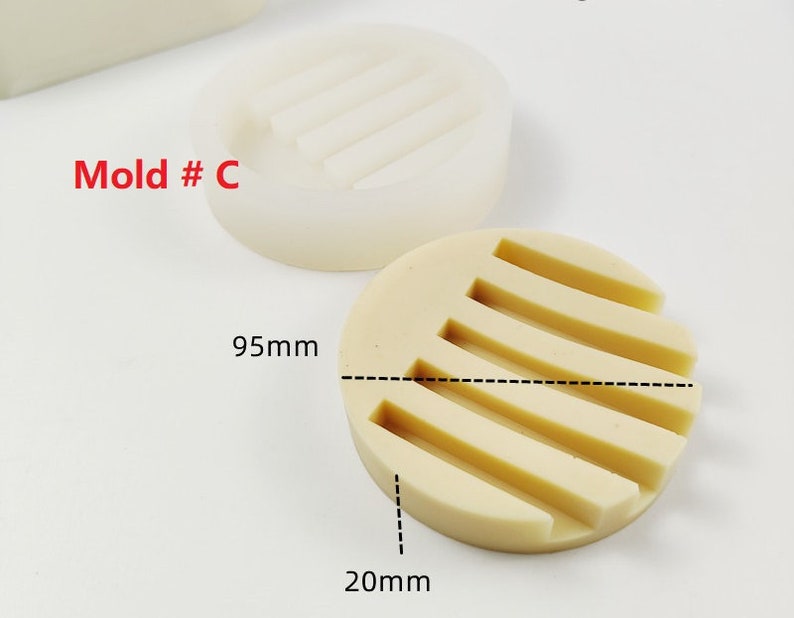Op de afbeelding: Een witte siliconen mal met een rechthoekige vorm en een reeks verhoogde lijnen. De mal is gemarkeerd met "Mold # C". De mal meet 95 mm in diameter en 20 mm in hoogte.