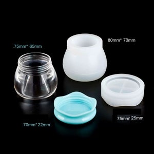 May include: Four silicone moulds for making soap or candles. The moulds are white and have different shapes and sizes. The largest mould is 80mm by 70mm, the smallest is 75mm by 25mm, and the other two are 75mm by 65mm and 70mm by 22mm.