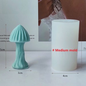 K&ouml;nnte beinhalten: Zwei Silikonformen zum Herstellen von pilzf&ouml;rmigen Objekten. Die Form links ist 6,5 cm hoch, 3 cm breit und hat ein hellblaues Pilzdesign. Die Form rechts ist 7,8 cm hoch, 4 cm breit und wei&szlig;. Der Text "# Medium mold" ist in Rot auf der rechten Form geschrieben.