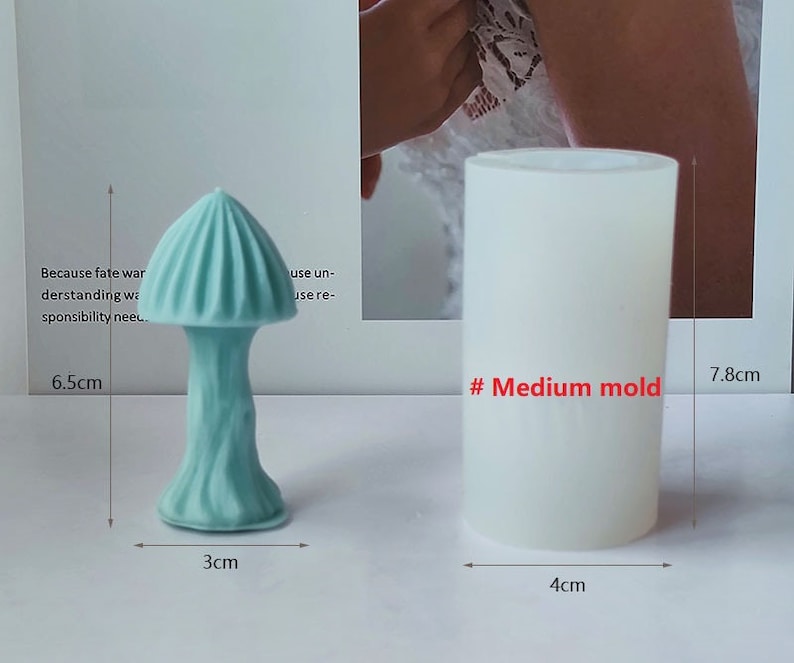 K&ouml;nnte beinhalten: Zwei Silikonformen zum Herstellen von pilzf&ouml;rmigen Objekten. Die Form links ist 6,5 cm hoch, 3 cm breit und hat ein hellblaues Pilzdesign. Die Form rechts ist 7,8 cm hoch, 4 cm breit und wei&szlig;. Der Text "# Medium mold" ist in Rot auf der rechten Form geschrieben.