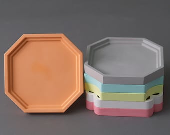 May include: A set of six octagonal coasters in various pastel colors, including gray, light blue, yellow, white, and pink. The coasters are stacked on top of each other.