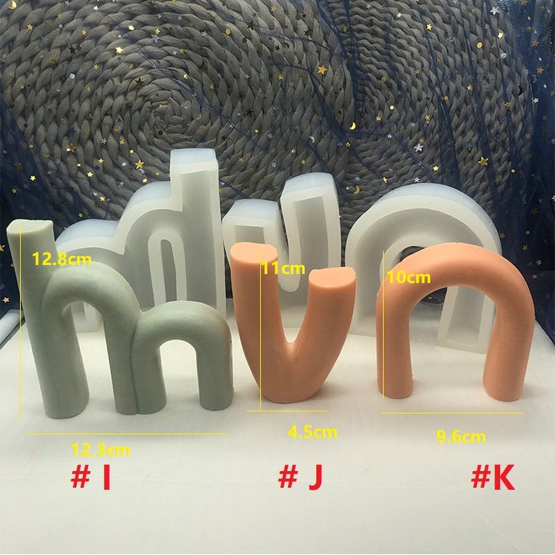 May include: Three silicone molds for making letters, shaped like the letters "H", "V", and "N". The molds are green, orange, and pink. The molds are labeled with numbers and measurements in centimeters.